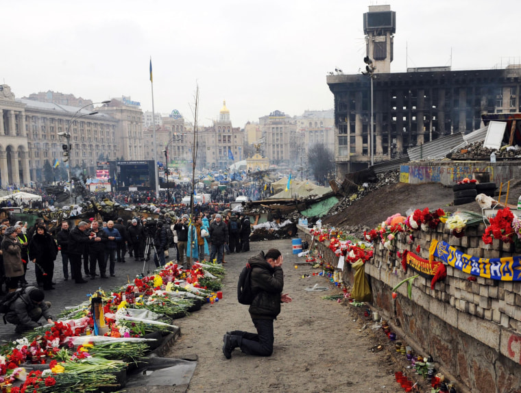 Image: A man cries at a memorial to the anti-government protesters killed in the past weeks clashes with riot police on Kiev's Independence Square on February 23, 2014.