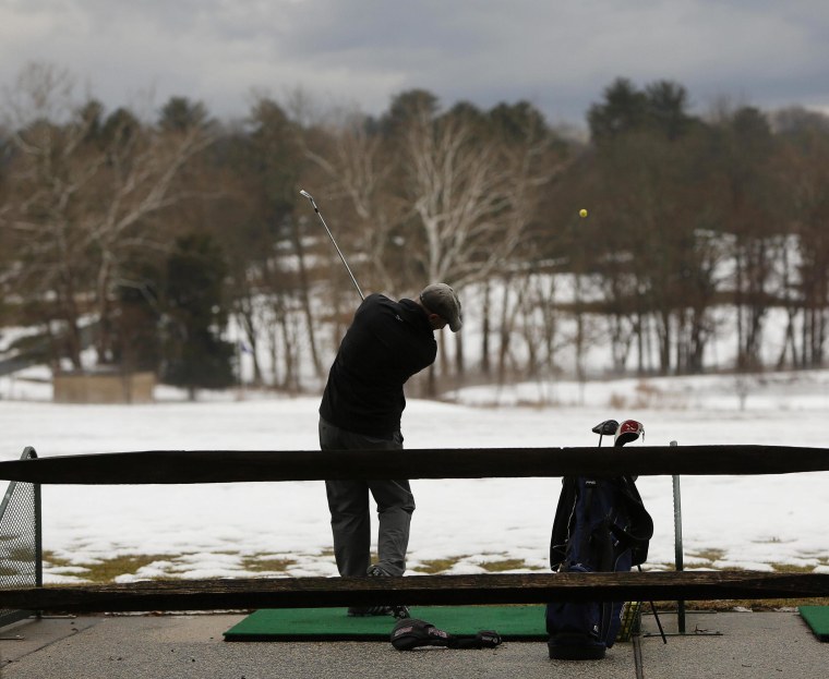 Image: Lone golfer works on his game under ominous skies at Northwest Golf Course in Silver Spring