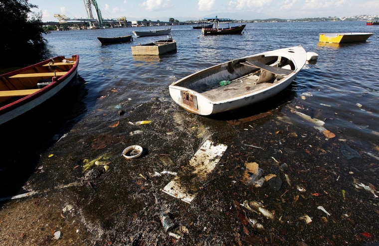 Image: Boats float along the shoreline of the polluted waters of Guanabara Bay in Rio de Janeiro