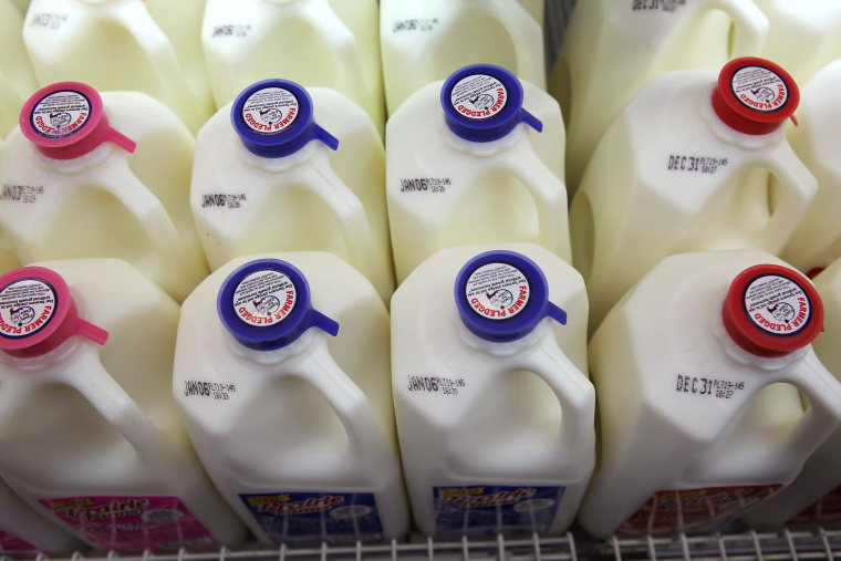 Image: Jugs of milk on a shelf at a grocery store.