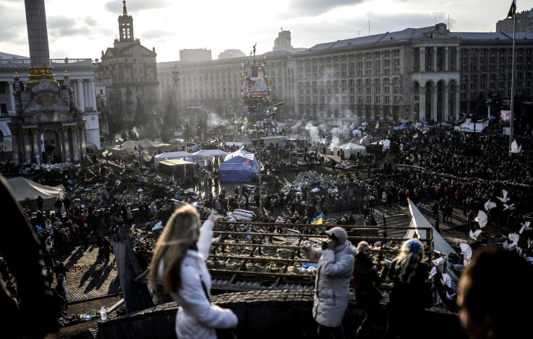 Image: People watch the Independence Square from a balcony.
