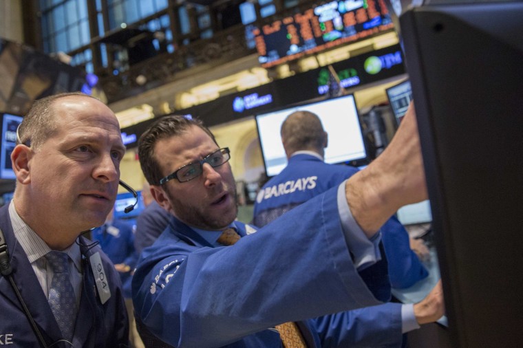 Traders work on the floor of the New York Stock Exchange on Monday when the S&P 500 hit a record high