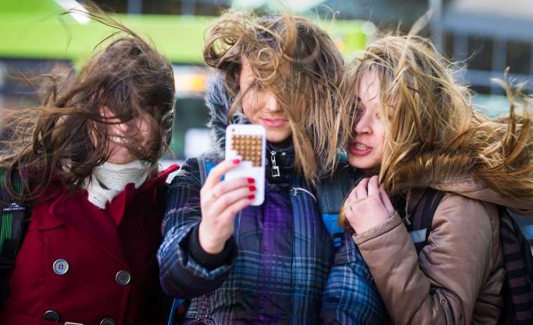 Image: Three young women take a group selfie of their hair flying in the wind