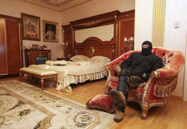 Image: A man sits on a chair in the house of Ukraine's former prosecutor general Pshonka in the village of Gorenichy outside Kiev