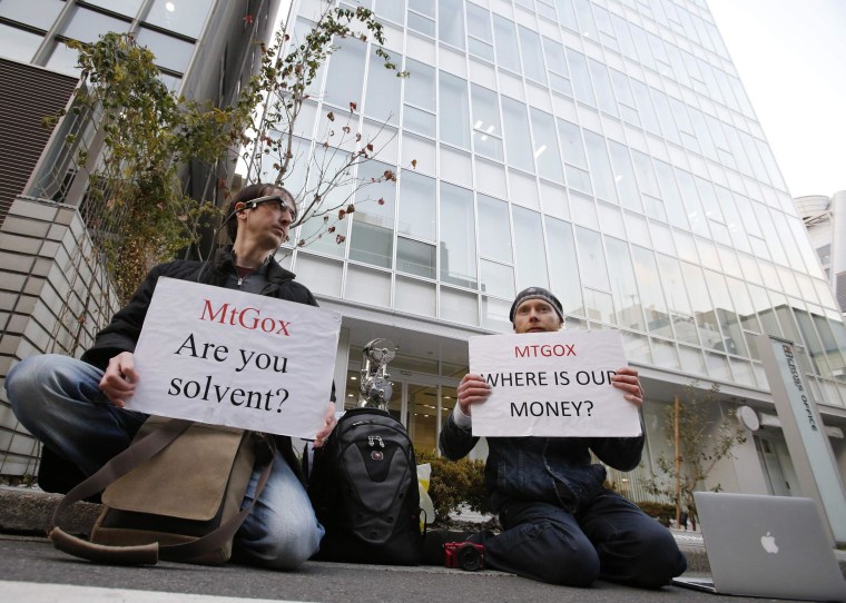 Protesters hold placards as they demonstrate against Mt. Gox in Tokyo