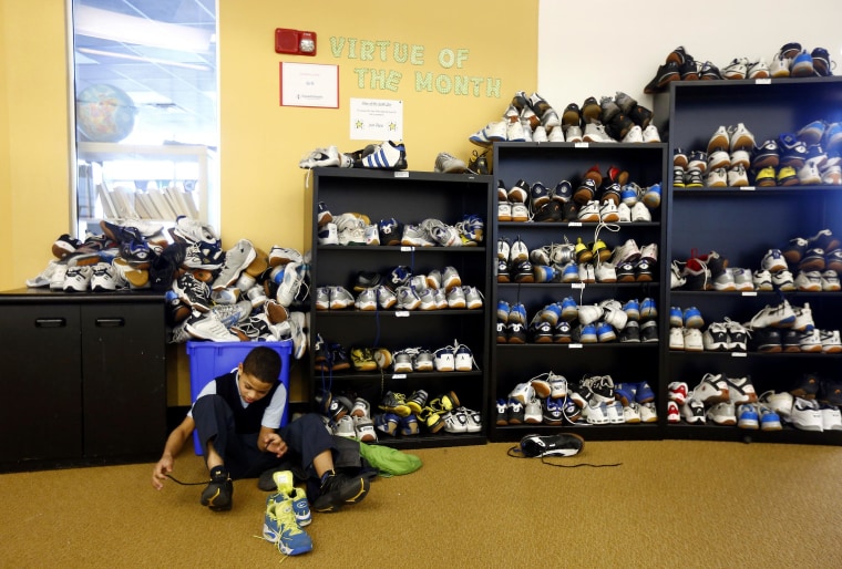 Image: Ramon Belliard, 10, puts his shoes on at the Lenfest Center