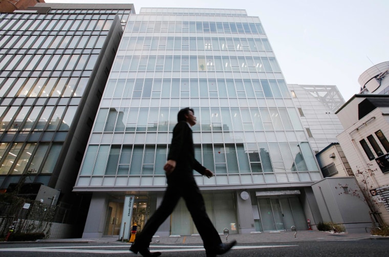 Image: A man walks past a building where Mt. Gox is housed in Tokyo