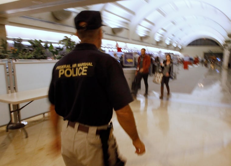 Image: A federal air marshal walks through a check-in area as travelers prepare to board flights at John Wayne Orange County Airport in Santa Ana, Calif.