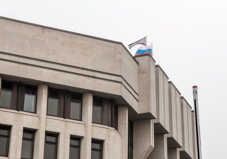 Image: A view of the Crimean parliament building in Simferopol with a Russian flag raised above it