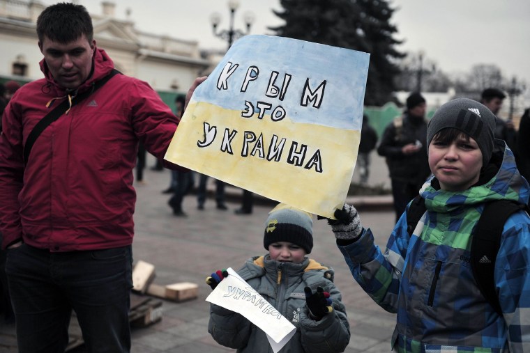 Image: People hold a sign reading "Crimea is Ukraine"