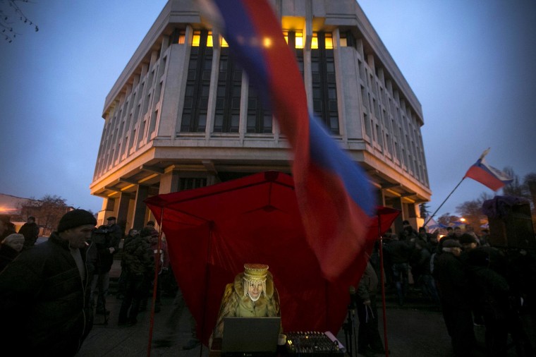 Image: Pro-Russian DJ in traditional clothing looks at her computer during a rally outside the Crimean parliament building in Simferopol