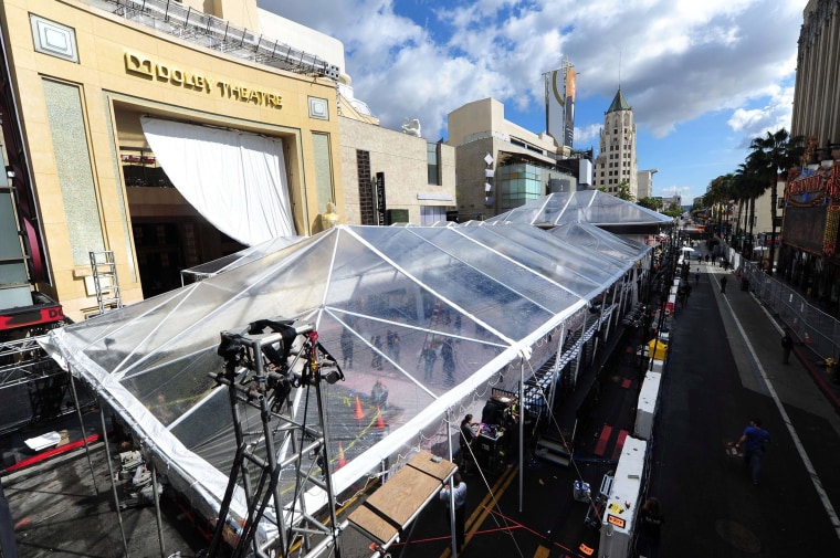 Image: A giant tarp provides the cover for expected rain as preparations continue on a covered-up Red Carpet along Hollywood Boulevard