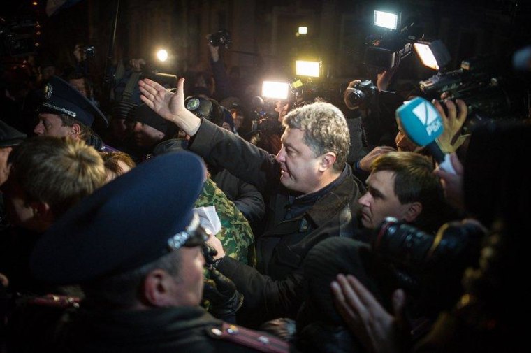 A crowd of angry pro-Russian demonstrators, as well as police and media, accompany Ukrainian MP Petro Poroshenko as he walks through the streets of the Crimean city of Simferopol.