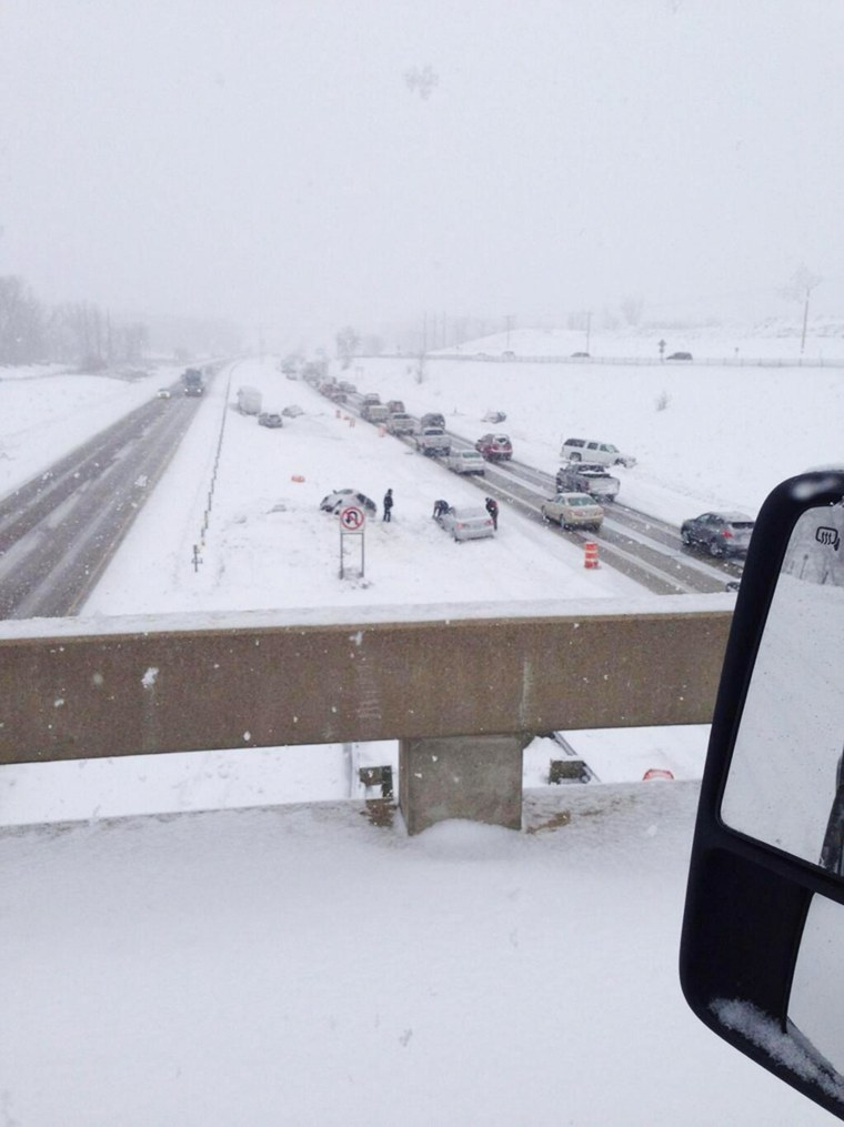 Image: Cars along a snowy highway after multiple crashes caused a lane closure on a Minnesota highway