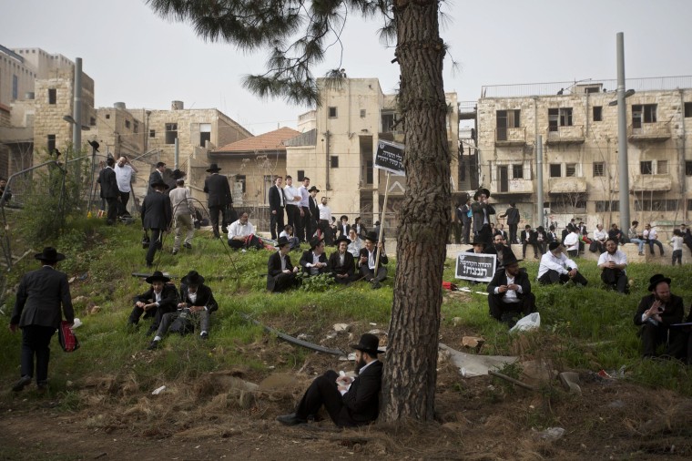 Image: Ultra-Orthodox Jewish men sit during a rally in Jerusalem