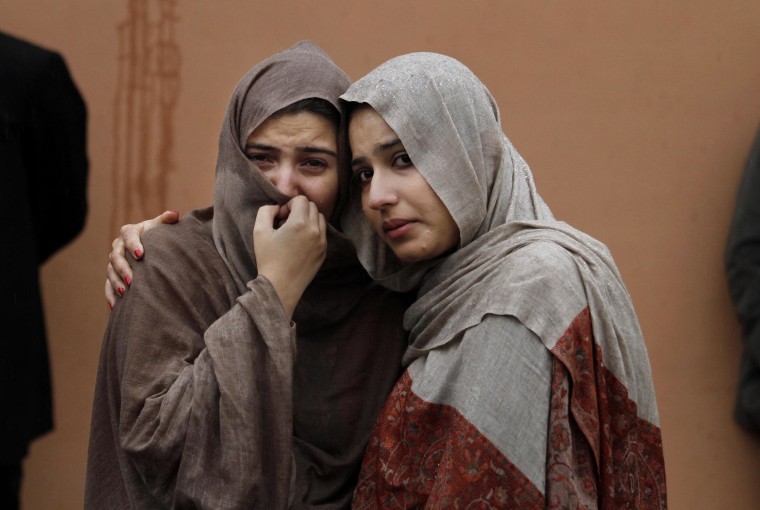 Image: Two women mourn outside a hospital morgue where the bodies of victims were brought.