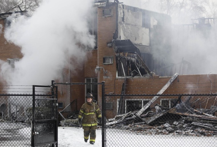 Image: A fireman walks away from an apartment building after it was destroyed by a four-alarm blaze on Detroit's west side early
