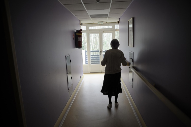 A woman, suffering from Alzheimer's desease, walks in a corridor on March 18, 2011 in a retirement house in Angervilliers, eastern France. 