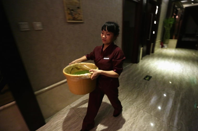 Image: Wang Feng carries a bucket of water at Huaxia Liangtse Wangjing store, in Beijing