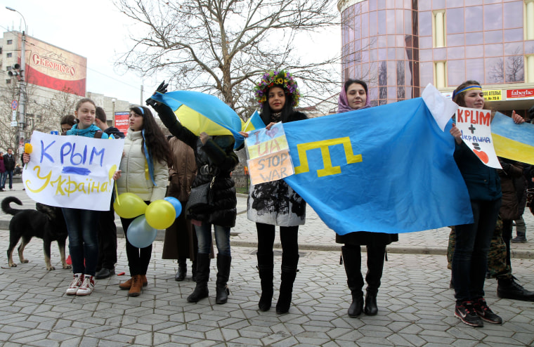 Protesters in Simferopol today wave Ukrainian and Tatar flags and signs that say "Crimea is Ukraine."