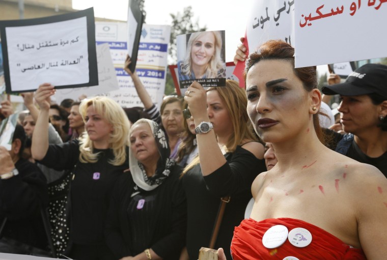 Image: A woman with make-up made to look like a bruise walks with families of victims of domestic violence during a march against domestic violence against women, marking International Women's Day in Beirut