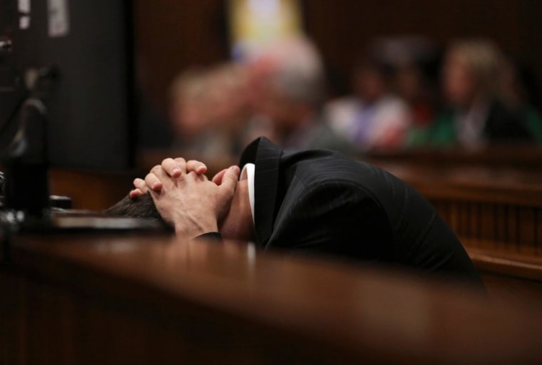 Image: Oscar Pistorius puts his hands over his head, in dock during his trial for murder of his girlfriend Steenkamp, at North Gauteng High Court in Pretoria