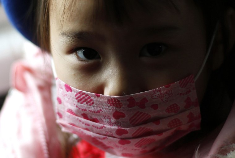 Image: A girl wearing a mask sits in a school bus heading to the Emporium kindergarten in Koriyama