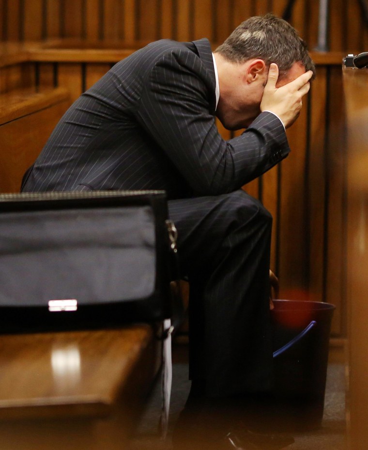 Image: Olympic and Paralympic track star Oscar Pistorius reacts as he reaches for a bucket in the dock during his trial for the murder of his girlfriend Reeva Steenkamp, at the North Gauteng High Court in Pretoria