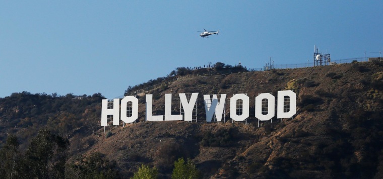 Image: A LAPD helicopter flies over the Hollywood sign in Hollywood