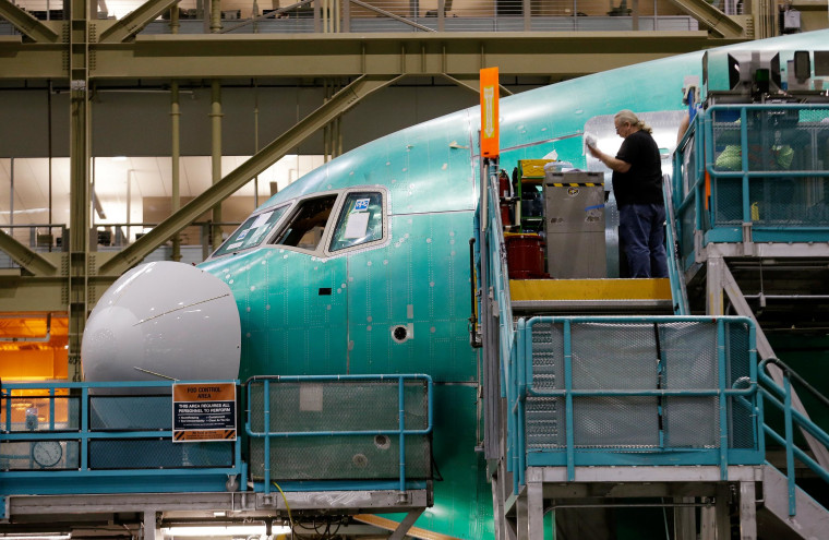 A worker stands near the front of a Boeing 777 jet under construction