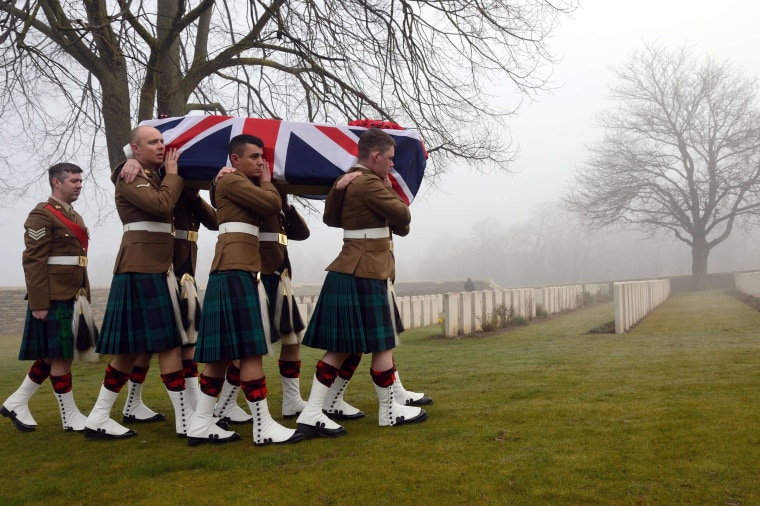 Image: Soldiers carry the flag-draped casket of British soldier William McAleer