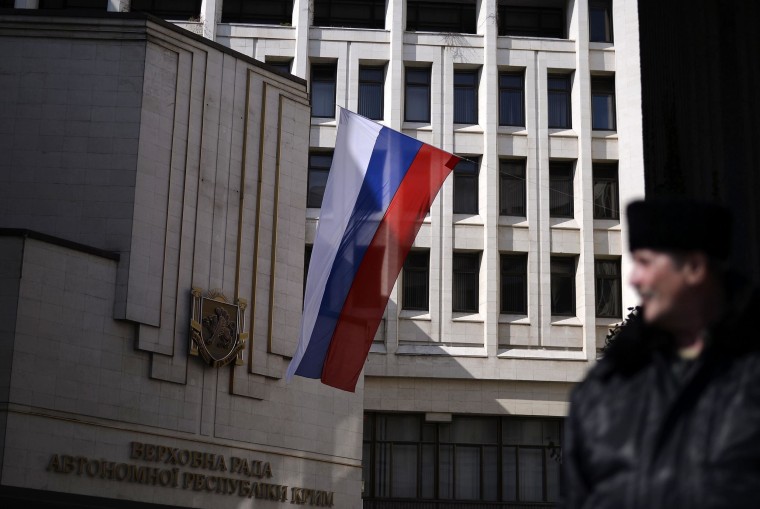 Image: A pro-Russian Cossack man stands guard in front of Crimea's regional parliament building