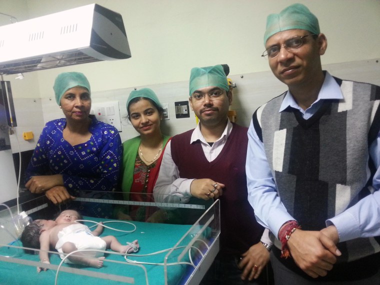 Image: Hospital staff stand next to the girl born with two heads