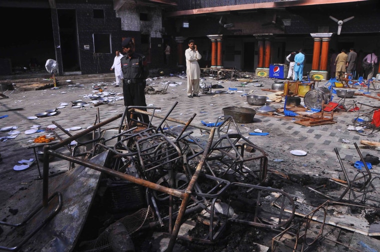 Image: A security official and members of the Hindu community stand inside a temple that was attacked on Saturday night, in Larkana