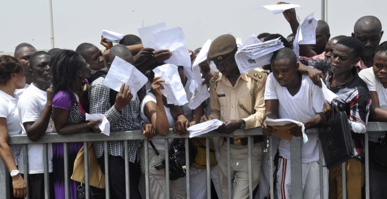 Image: Applicants struggle to submit copies of their acknowledgement forms to an immigration officer during a recruitment drive for the Nigeria Immigration Service at the National Stadium in Abuja