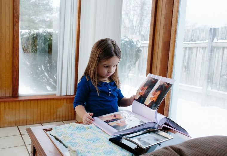Image: Isabella looks through a scrapbook with images of Sophia