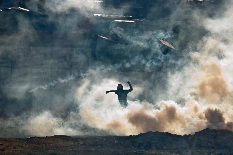 Image: An anti-government demonstrator prepares to throw a rock
