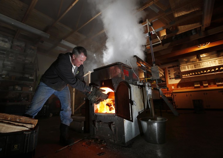 Image: Paul Boulanger tosses wood in to fire up the sap evaporator at the Turtle Lane Maple sugar house in North Andover, Mass. on March 13.