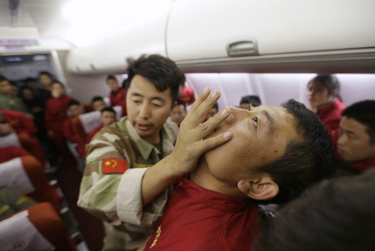 Image: An instructor pushes a student's jaw during a special course on flight safety on the outskirts of Beijing