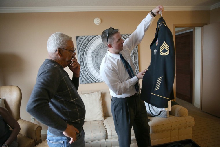Image: U.S. Army Staff Sergeant Melvin Morris, a Vietnam War veteran, watches as U.S. Army Staff Sergeant Christopher Schneider, right, from U.S. Army Old Guard, 3d U.S. Infantry Regiment, inspects his uniform to prepare him for his visit to the White Hou