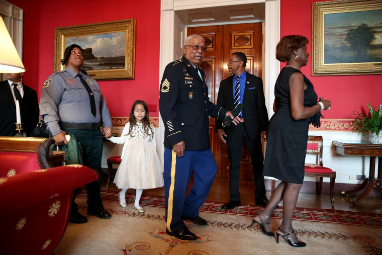 Image: U.S. Army Staff Sgt. Melvin Morris, a Vietnam War veteran, center, walks with his family before a ceremony to receive the Medal of Honor in the White House