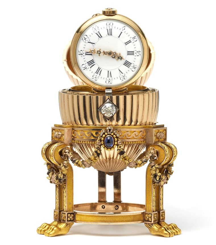 Image: A rare Imperial Faberge Egg with the top open to reveal a clock