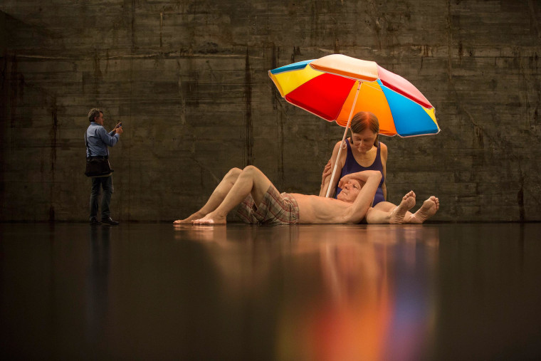 A man photographs a sculpture entitled 'Couple under an Umbrella' by Australian artist Ron Mueck during the opening day of his exhibition at the Museum of Modern Art in Rio de Janeiro, Brazil, on March 19. The exhibition will run up to June 1, 2014.