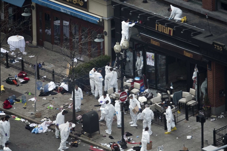 Image: Officials take crime scene photos in front of the damaged Forum restaurant a day after two explosions hit the Boston Marathon