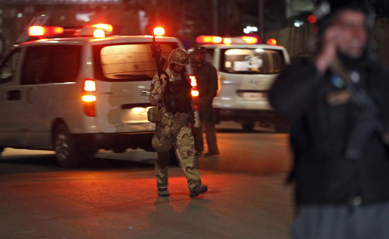 Image: An Afghan policeman walks at the site of a gun battle in Serena Hotel in Kabul