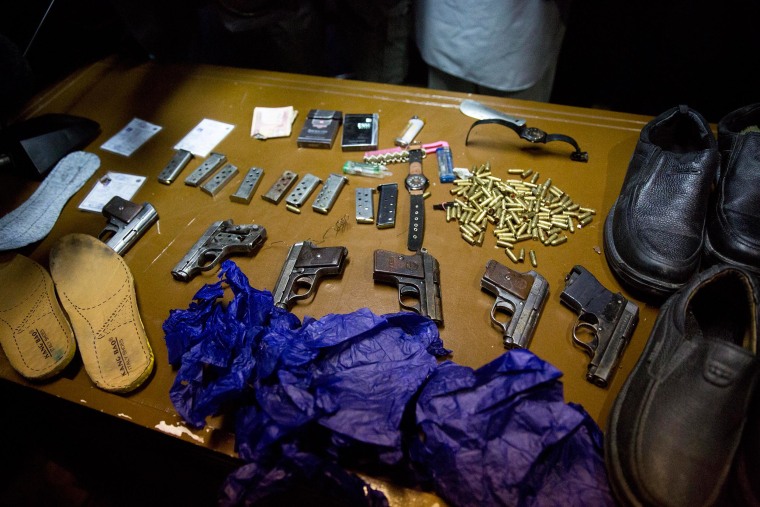 Image: Afghanistan's intelligence service displays some of the weapons and belongings of attackers on the Serena Hotel