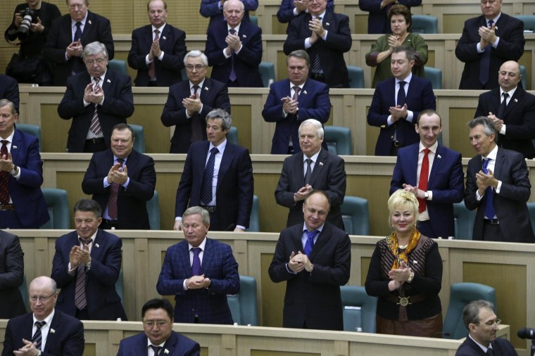 Image: Members of the Federation Council, Russia's upper house of parliament, applaud during a session in Moscow