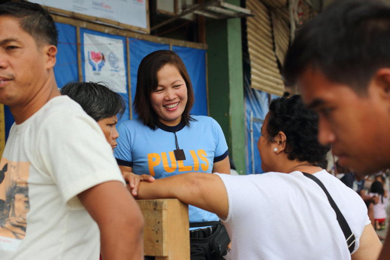 Image: Members of an all-women police unit patrol a camp set up in the wake of Typhoon Haiyan