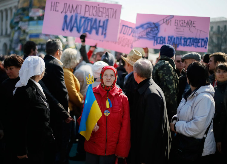 Image: A woman holds a Ukranian flag as she attends an anti-war rally at Independence Square in Kiev