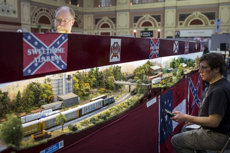 Image: A model railway enthusiast controls working model trains